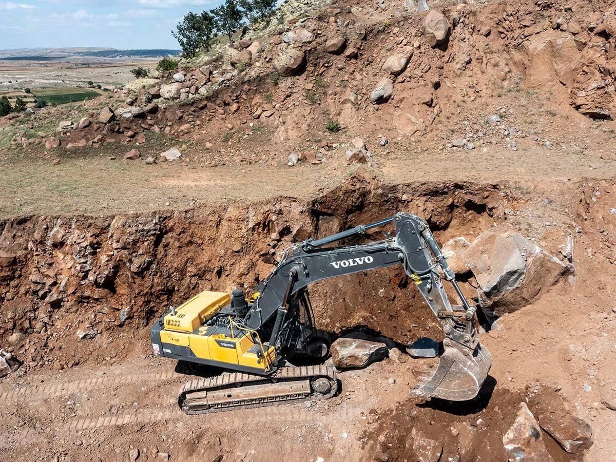 Excavator extracting natural stone block at a Türkiye quarry